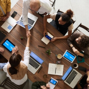 Multiplicidad de personas colaborando en reunión de trabajo con laptops y tablets, concepto de colaboración y negocios.